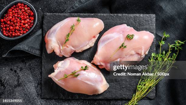 raw boneless chicken thighs fillet black background top view,pakistan - uncooked chicken photos et images de collection