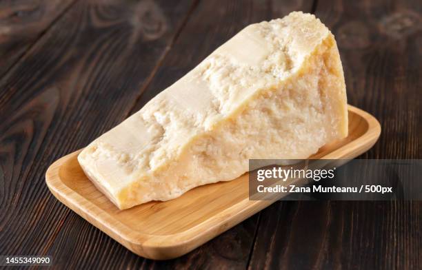 wedge of parmesan cheese on wooden background,romania - cheese wedge foto e immagini stock