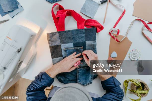 fashion designer stitching pocket on shopping bag - zoom in stockfoto's en -beelden