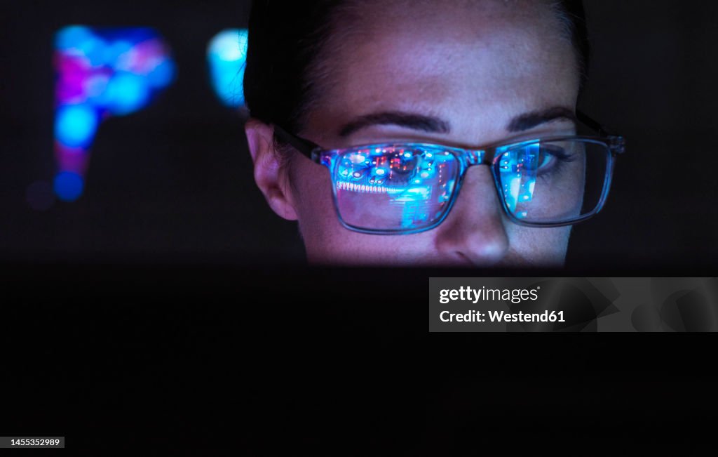 Engineer designing AI technology with reflection on eyeglasses