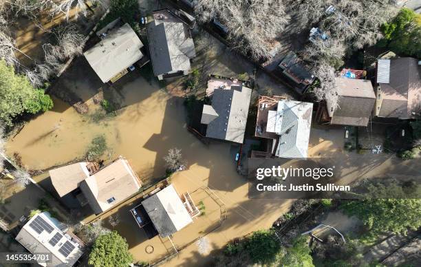 In an aerial view, floodwaters surround homes in a neighborhood on January 09, 2023 in Guerneville, California. The San Francisco Bay Area continues...