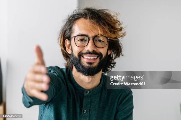 happy freelancer reaching for handshake at office - inviting gesture stock pictures, royalty-free photos & images