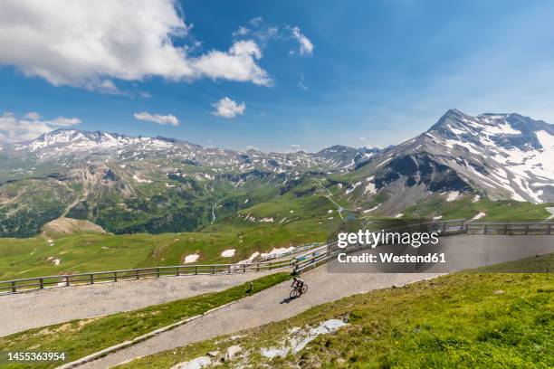 austria, carinthia, person riding bicycle down grossglockner high alpine road - hohe tauern stock pictures, royalty-free photos & images