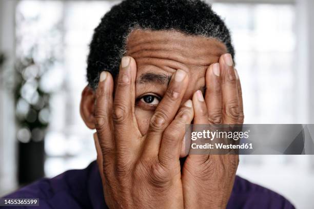 mature man covering face with hands - peeking over stock pictures, royalty-free photos & images