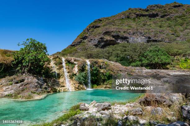 oman, dhofar, salalah, turquoise pond and waterfalls of wadi darbat river - salalah oman stock pictures, royalty-free photos & images