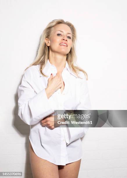 smiling woman wearing white shirt standing in studio - surexposition effet visuel photos et images de collection
