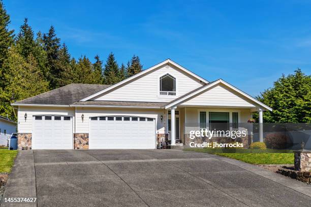 single story suburban home exterior with large driveway - gelijkvloers huis stockfoto's en -beelden