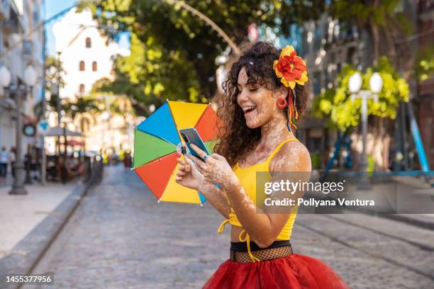 teenager mädchen mit smartphone auf der straße in recife, pernambuco - carnaval woman stock-fotos und bilder