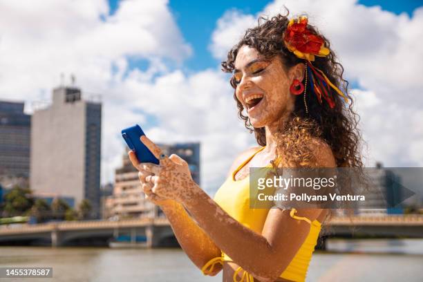 junge frau schickt online per smartphone eine nachricht - karneval stock-fotos und bilder