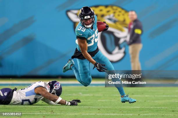 Jamal Agnew of the Jacksonville Jaguars runs from the tackle of Lonnie Johnson Jr. #20 of the Tennessee Titans at TIAA Bank Field on January 8, 2023...