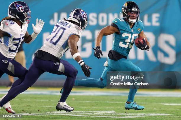 Jamal Agnew of the Jacksonville Jaguars runs from the tackle of Lonnie Johnson Jr. #20 of the Tennessee Titans at TIAA Bank Field on January 8, 2023...