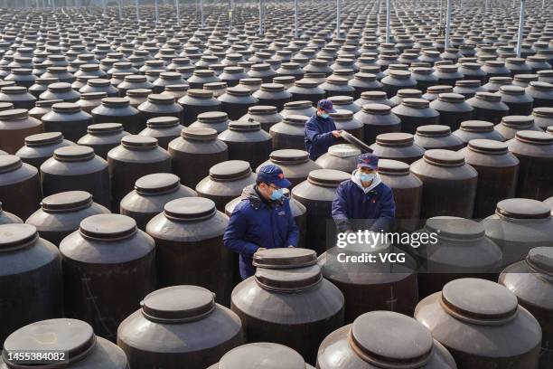 Workers check the drying condition of soy sauce at a factory of Hengshun Group on January 9, 2023 in Zhenjiang, Jiangsu Province of China.
