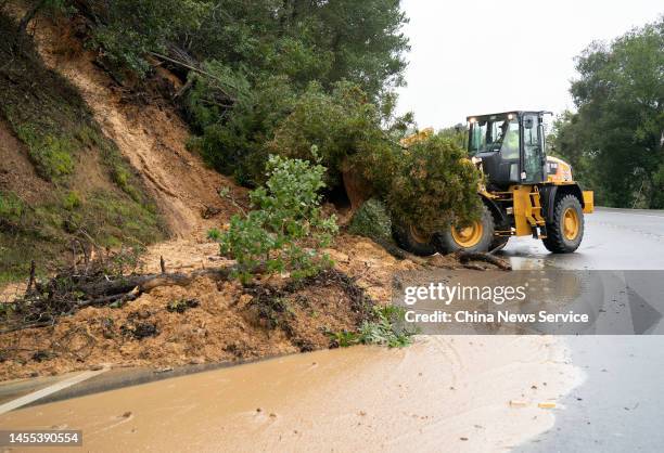 Worker operates a forklift to clear fallen trees and mud at the site of a landslide on January 9, 2023 in San Mateo County, California. U.S....