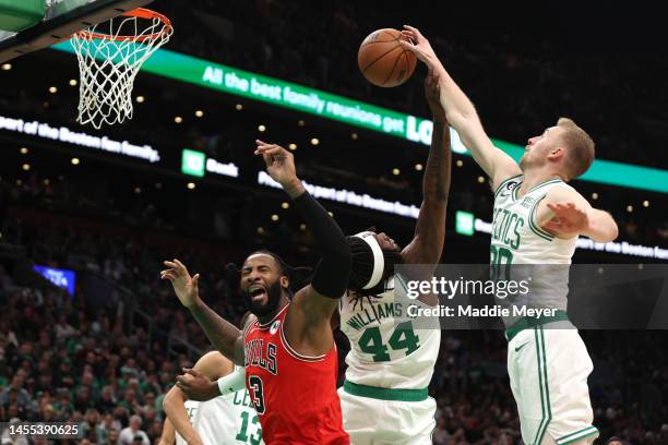 Sam Hauser of the Boston Celtics grabs a rebound over Andre Drummond of the Chicago Bulls during the second half at TD Garden on January 09, 2023 in...