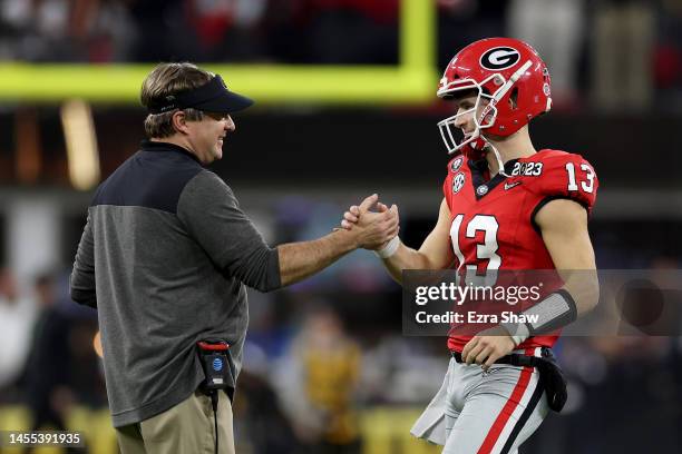 Stetson Bennett of the Georgia Bulldogs reacts with head coach Kirby Smart in the third quarter as he walks to the sideline against the TCU Horned...