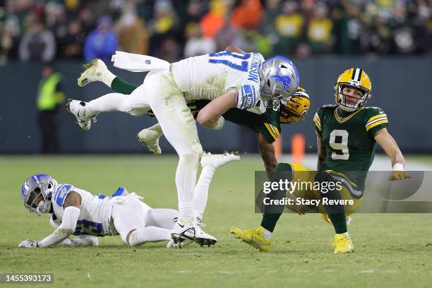 Aaron Jones of the Green Bay Packers is brought down by Aidan Hutchinson of the Detroit Lions during a game at Lambeau Field on January 08, 2023 in...
