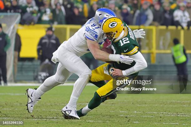 Aaron Rodgers of the Green Bay Packers is sacked by Aidan Hutchinson of the Detroit Lions during a game at Lambeau Field on January 08, 2023 in Green...