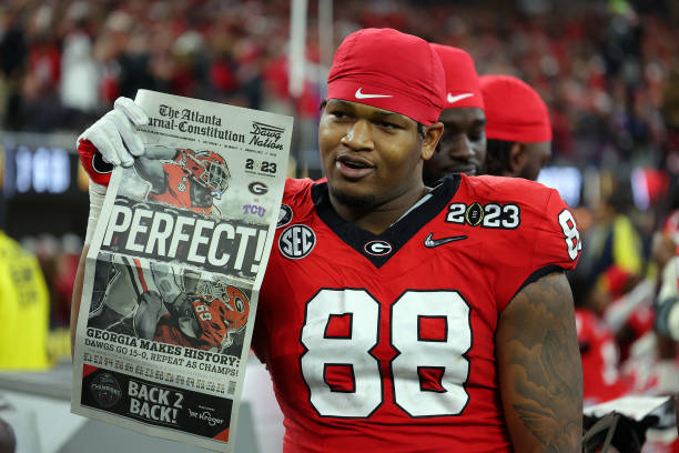 Jalen Carter of the Georgia Bulldogs celebrates with a newspaper reading "Perfect!" after defeating the TCU Horned Frogs in the College Football Championship
