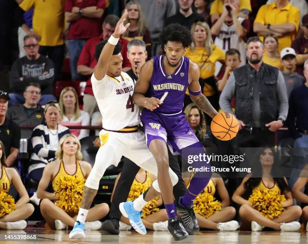 Keion Brooks Jr. #1 of the Washington Huskies posts up against Desmond Cambridge Jr. #4 of the Arizona State Sun Devils during the first half of the...