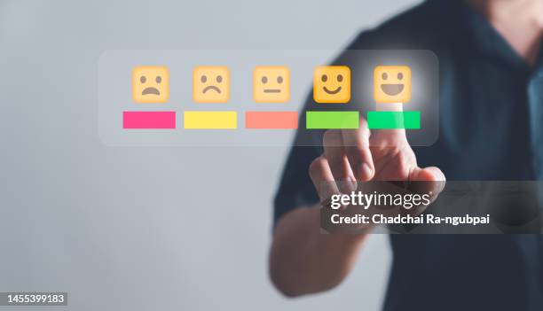customer service and satisfaction concept, purchaser people are touching the virtual screen on the happy smiley face icon to give satisfaction in service. rating very impressed. - screen awards stock-fotos und bilder