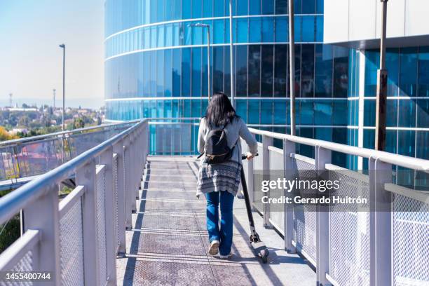 young woman using electric skateboard in the city - electric skateboard stock pictures, royalty-free photos & images