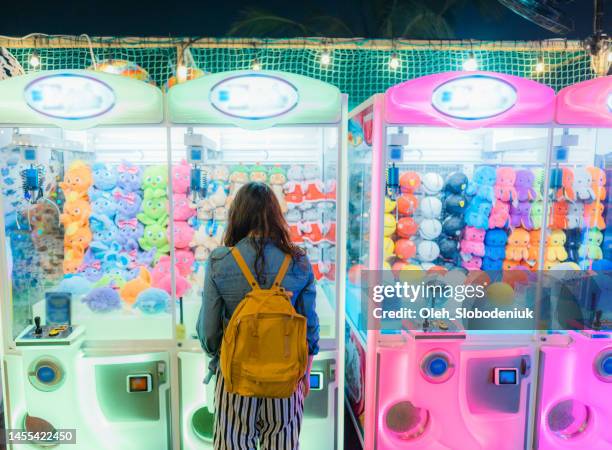 woman playing on claw machine - claw machine bildbanksfoton och bilder