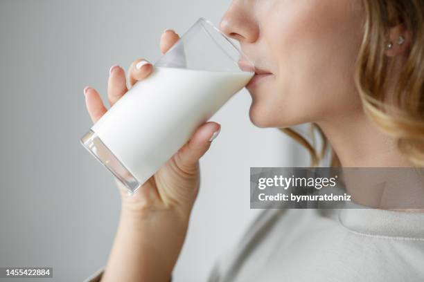 woman drinking a glass of milk - milk stockfoto's en -beelden