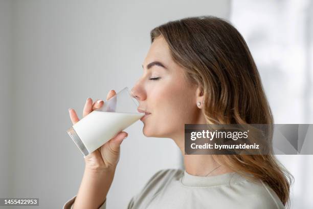 femme buvant un verre de lait - produit laitier photos et images de collection