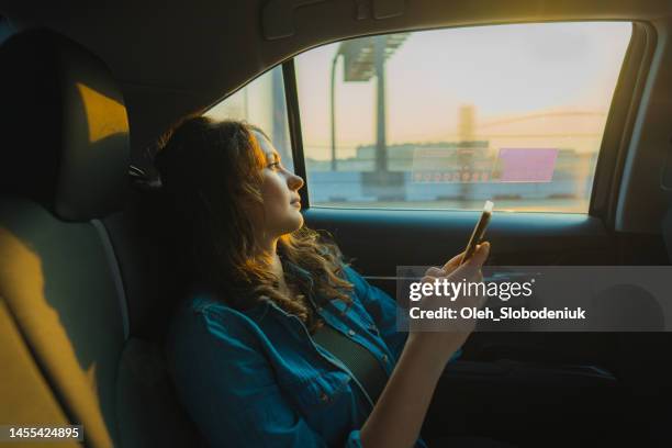 woman in taxi in dubai at sunset - modern arab woman stockfoto's en -beelden