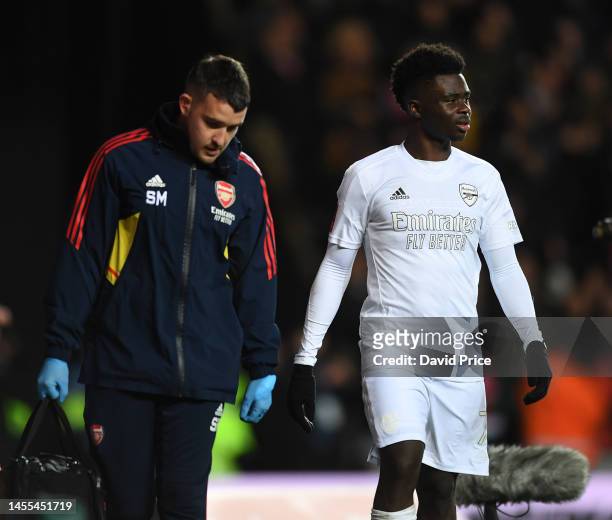 Bukayo Saka of Arsenal with Arsenal Physio Simon Murphy during the FA Cup 3rd round match between Oxford United and Arsenal at Kassam Stadium on...