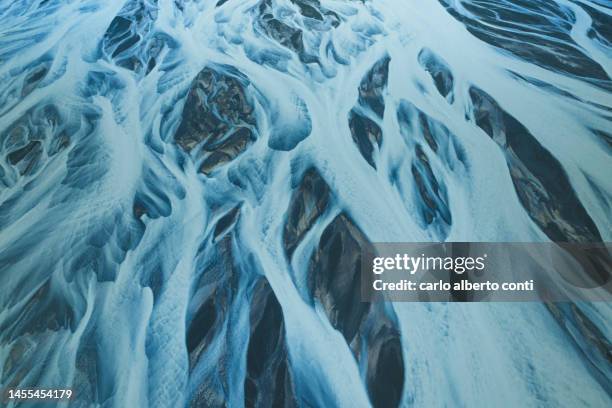 aerial abstract view taken by drone of icelandic glacial river during an autumn day, iceland, europe - kalfafell iceland stock pictures, royalty-free photos & images