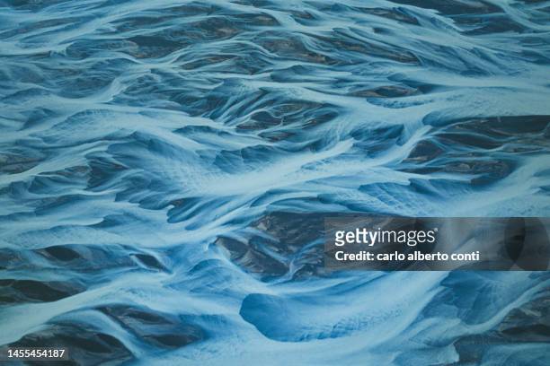 aerial abstract view taken by drone of icelandic glacial river during an autumn day, iceland, europe - kalfafell iceland stockfoto's en -beelden