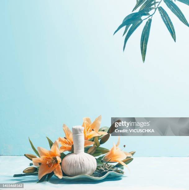 herbal massage stamp with yellow flowers at blue background - massagebal stockfoto's en -beelden