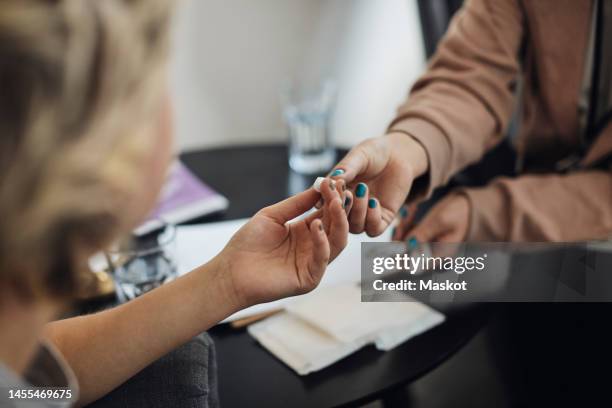 mental health professional giving tampon to teenage female student - girl using tampon stockfoto's en -beelden