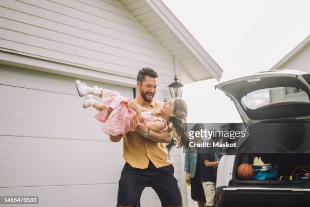 happy father playing with daughter by electric car outside house - arab family outdoor bildbanksfoton och bilder