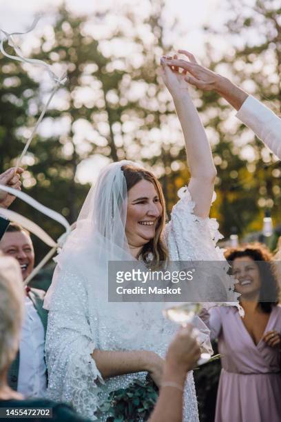 happy newlywed couple dancing amidst family and friends at wedding - arabic wedding stock pictures, royalty-free photos & images