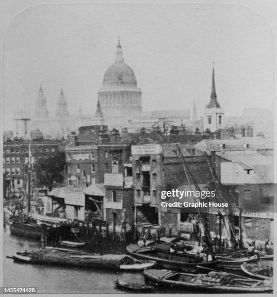 Wharves and boats on the River Thames, with the dome of St Paul's Cathedral rising beyond in the City of London, England, circa 1875. View taken from...