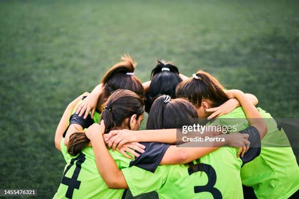 girls soccer team discussing game plan in a huddle on field - huddling stock pictures, royalty-free photos & images