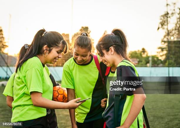 girl showing mobile phone to friends on soccer court after practice session - argentina training session stock pictures, royalty-free photos & images