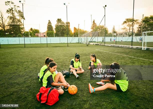 group of soccer girls sitting on field after training session - argentina training session stock pictures, royalty-free photos & images