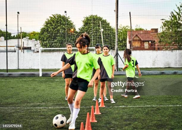 girls playing soccer on training football pitch - coordinated effort stock pictures, royalty-free photos & images