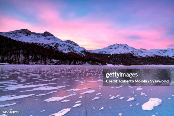 frozen alpine lake at dawn in winter, switzerland - cielo romantico foto e immagini stock