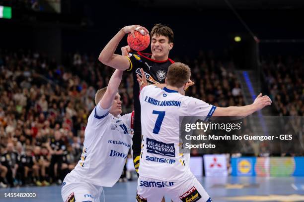 Julian Koester of Germany is tackled by Ymir Oern Gislason and Viggo Kristjansson of Iceland during the handball international friendly match between...