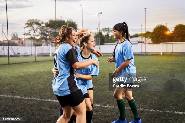 cheerful girls soccer celebrating a goal on sports field - soccer girl stockfoto's en -beelden