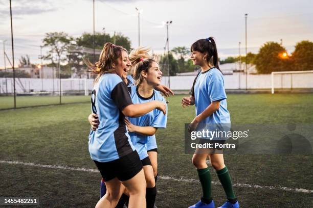 cheerful girls soccer celebrating a goal on sports field - soccer team stock pictures, royalty-free photos & images