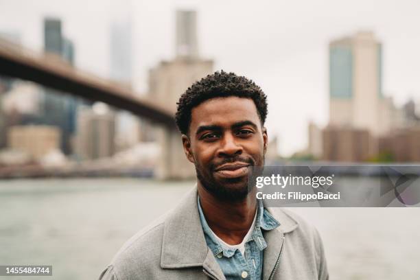 portrait of a cheerful millennial man in the city - mid volwassen mannen stockfoto's en -beelden