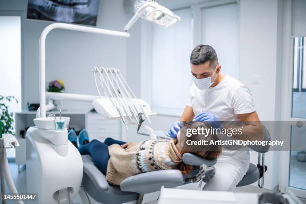 dentist examining female patient. - tandartsapparatuur stockfoto's en -beelden