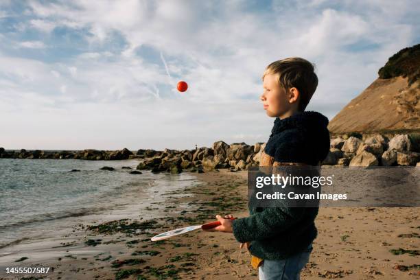 boy playing bat and ball happily at the beach - hitting stock pictures, royalty-free photos & images
