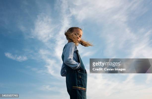 portrait of a girl stood with her hair blowing in the wind - wind stock pictures, royalty-free photos & images