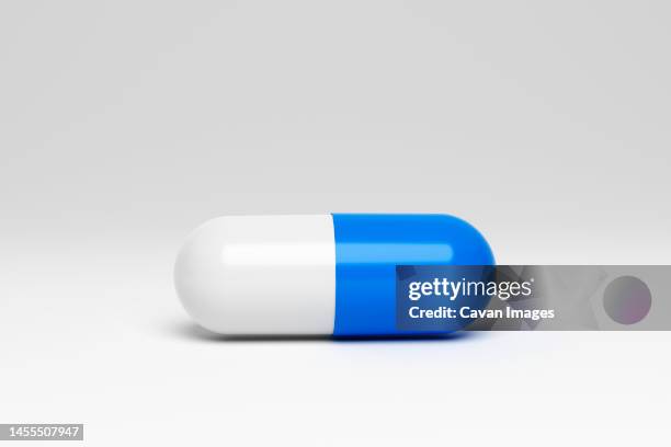 blue and white capsule on white background. 3d render - antibiotic pills stock pictures, royalty-free photos & images